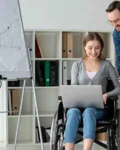 Wheelchair user working in a UK office, reflecting disability inclusion in employment.