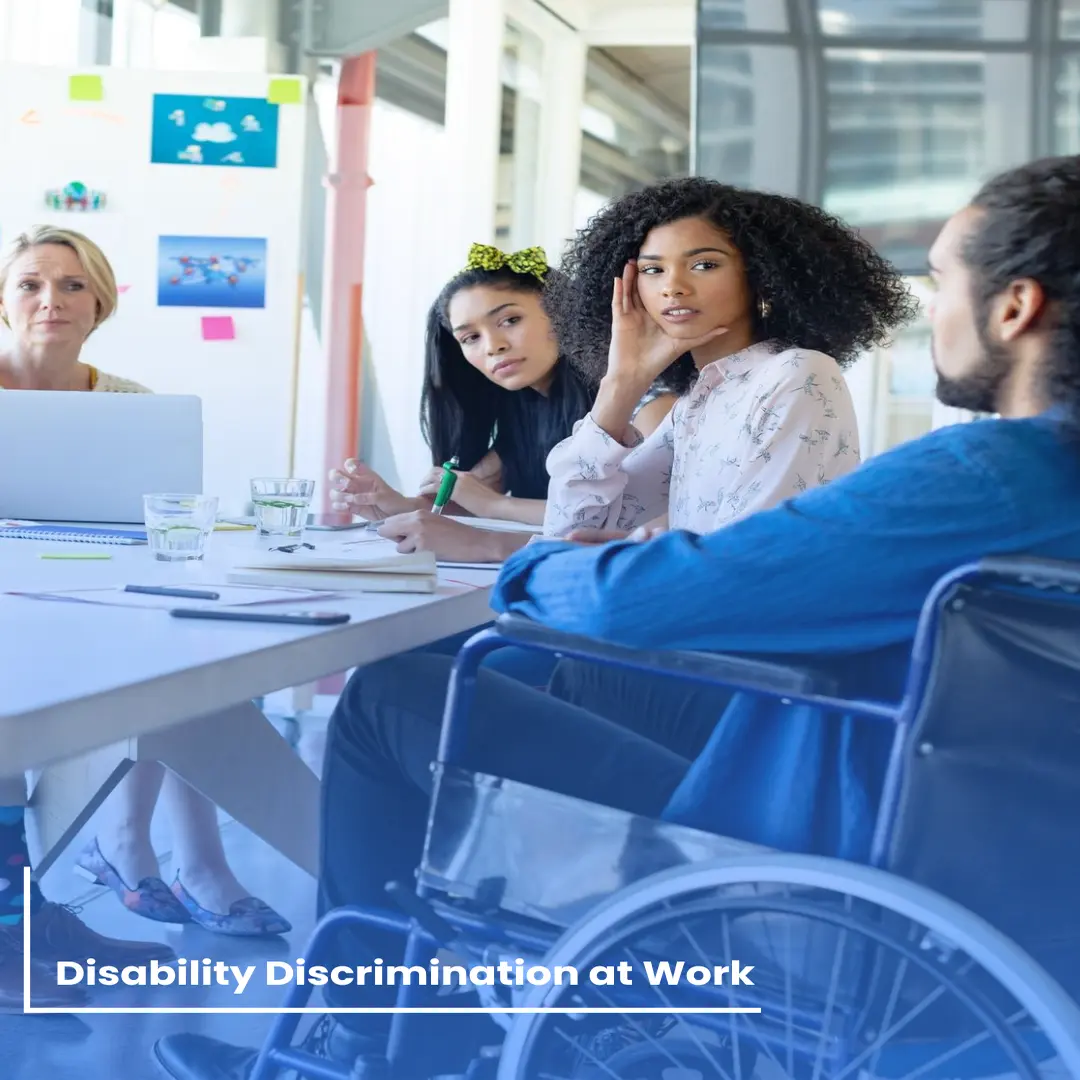 A team meeting with a wheelchair user present, representing workplace disability discrimination claims and employee rights
